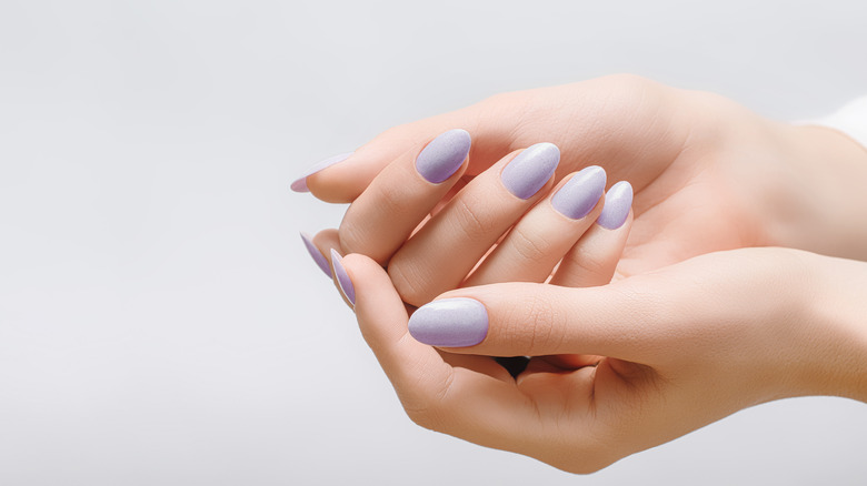 Woman displaying manicured nails, polish