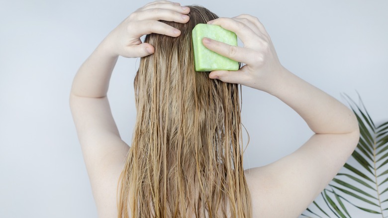 Blond using shampoo in shower