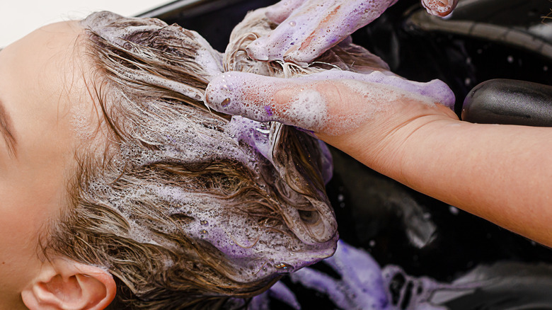 Woman getting wash with purple shampoo