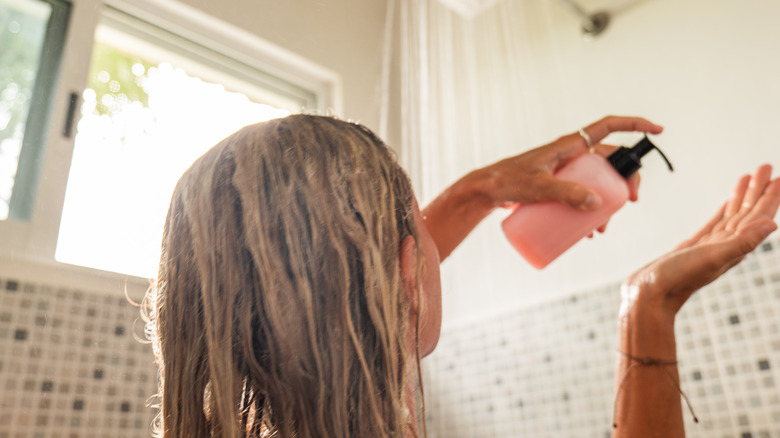 Woman holding shampoo bottle