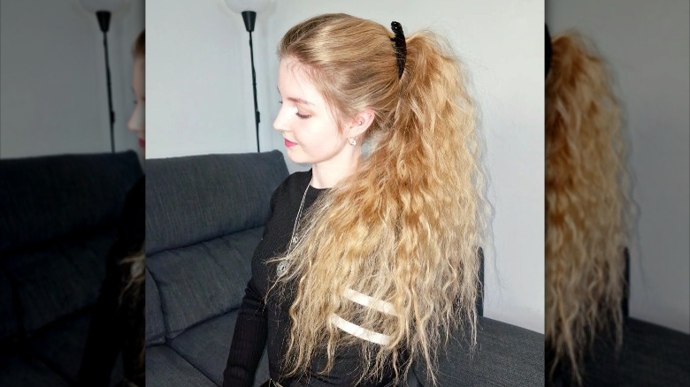 Person with curly hair in a ponytail