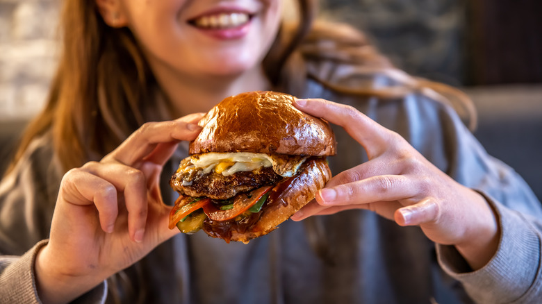 woman holding burger