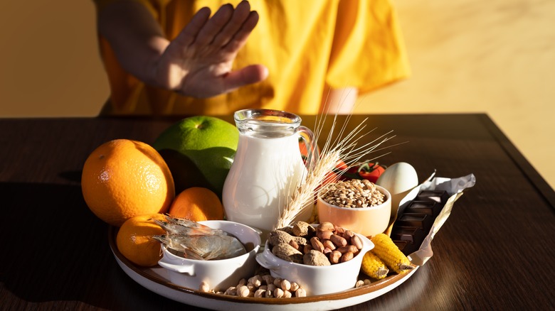 woman saying no to milk, nuts, wheat, fruit