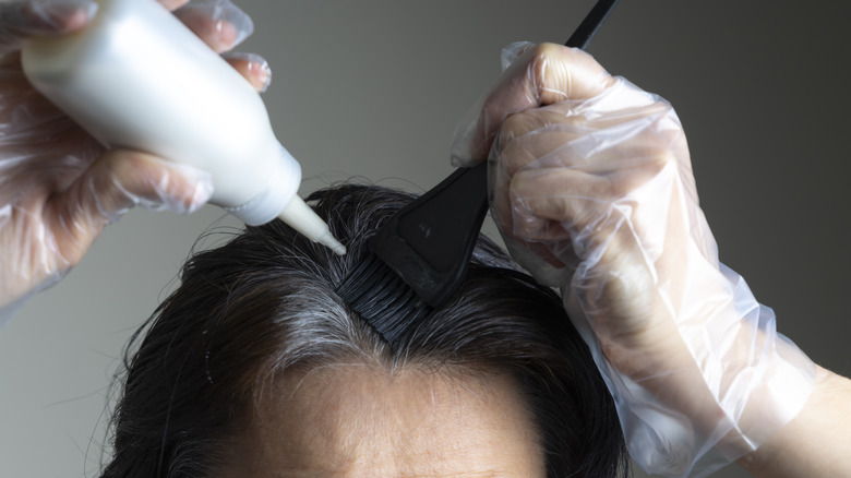 woman looking at gray hairs