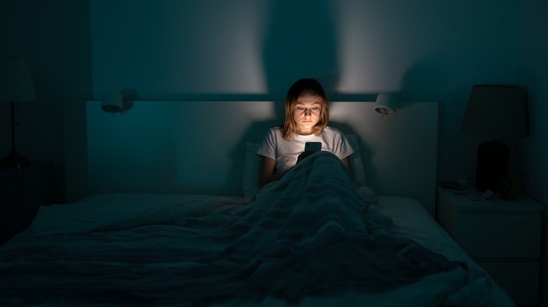 woman in bed with phone 