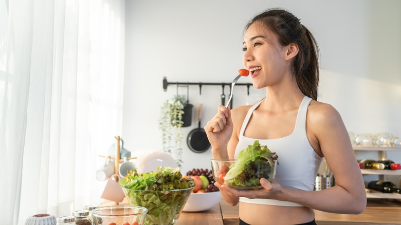 woman eating salad and cherry tomato