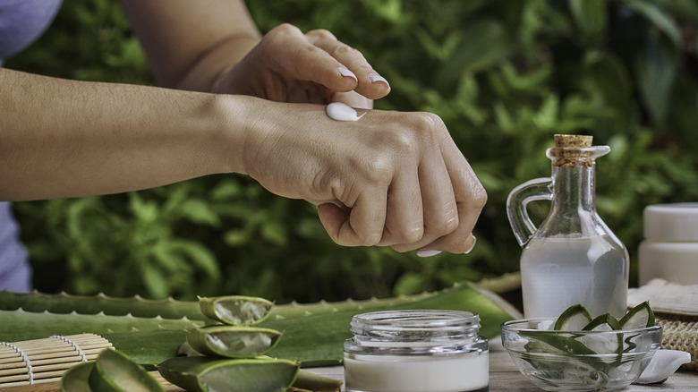 Woman moisturizing hands with aloe vera