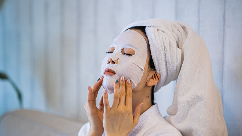 Woman applying sheet mask