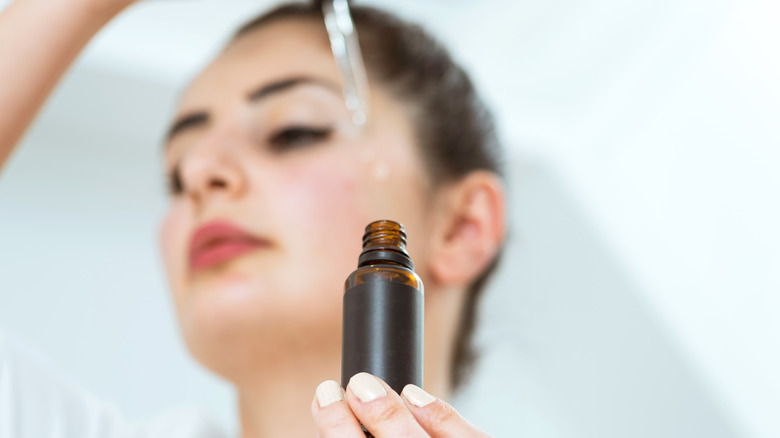 Woman applying face serum