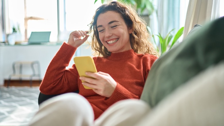 Woman smiling, using cell phone