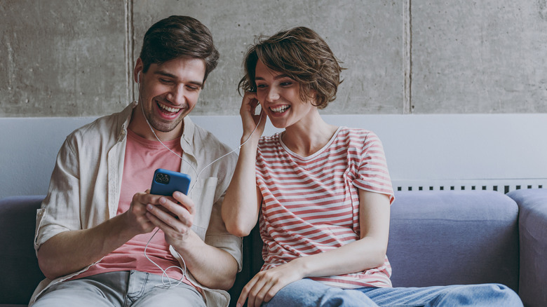 Happy couple sharing headphones 