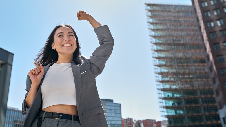 Successful woman cheering in city