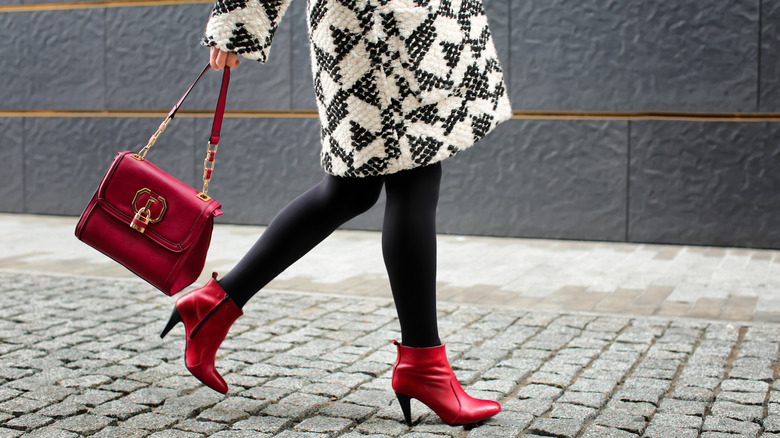 Person in black leggings and red ankle boots
