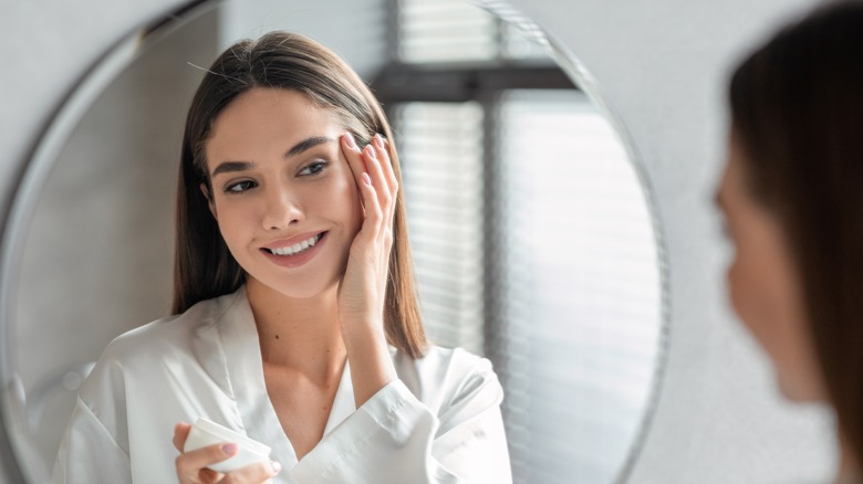 Woman applying color-correcting primer