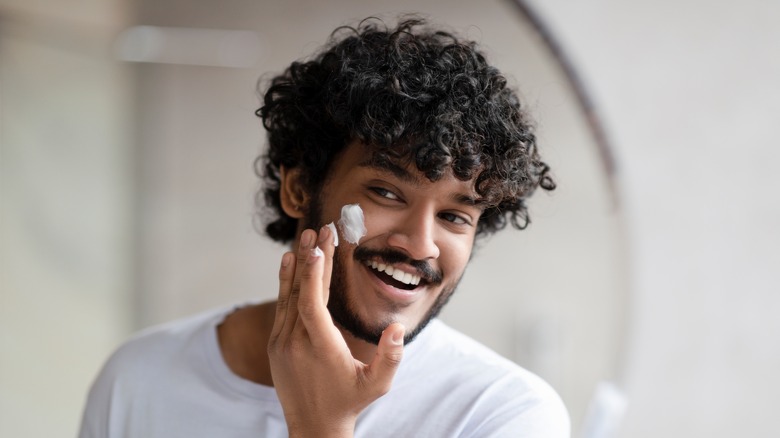 Man applying moisturizer to face