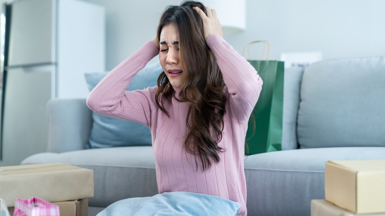 woman holding head overwhelmed with emotions