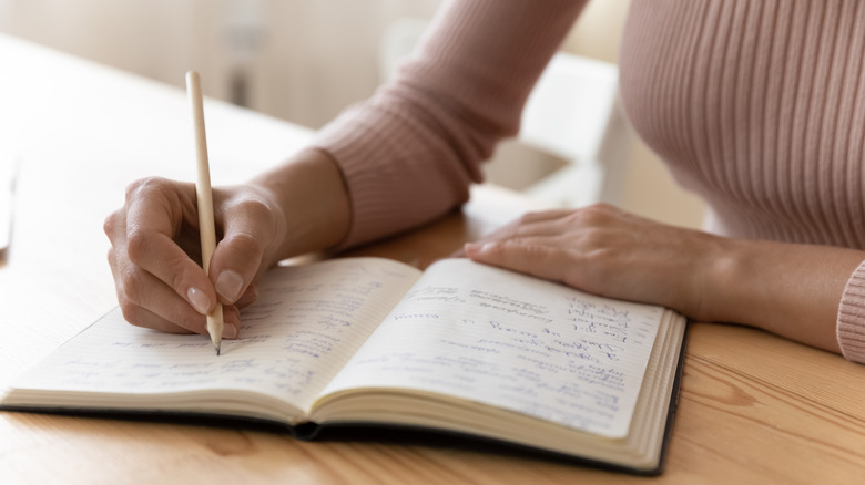 Woman writing in a journal 