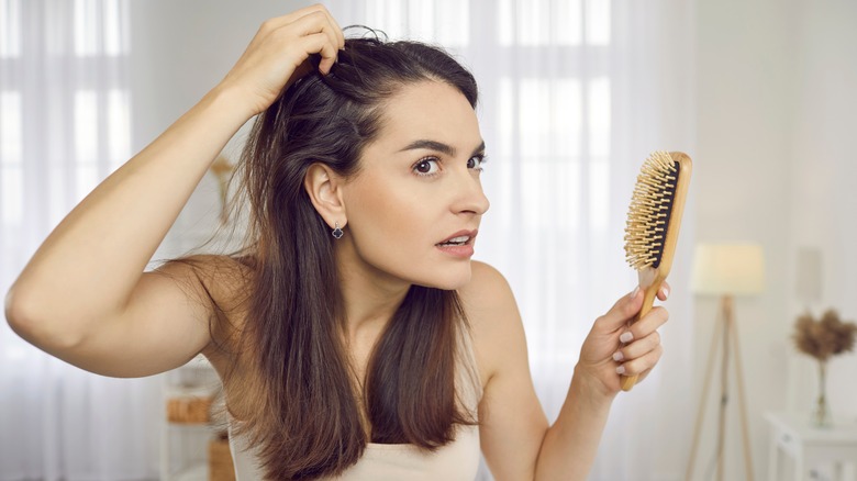 A woman looking at her scalp