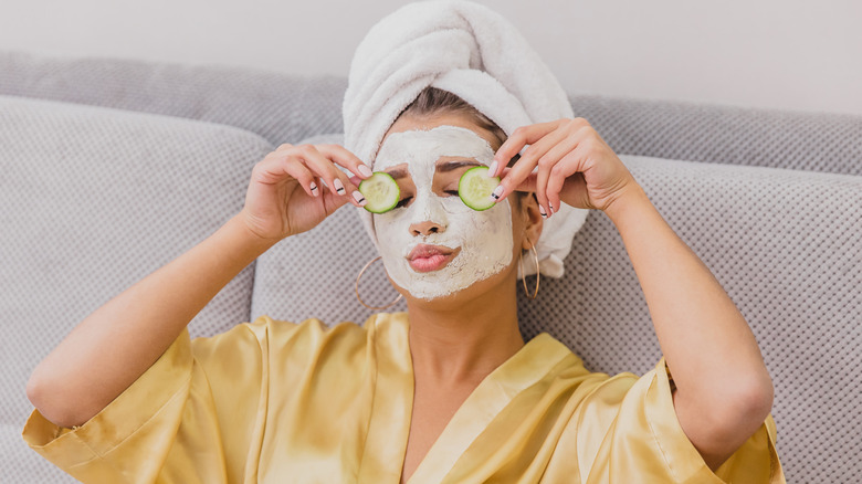 Woman wearing cucumbers on eyes