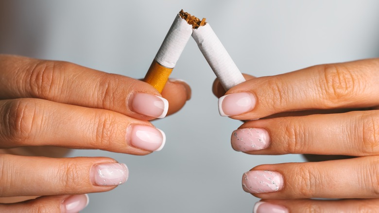Woman holding a broken cigarette