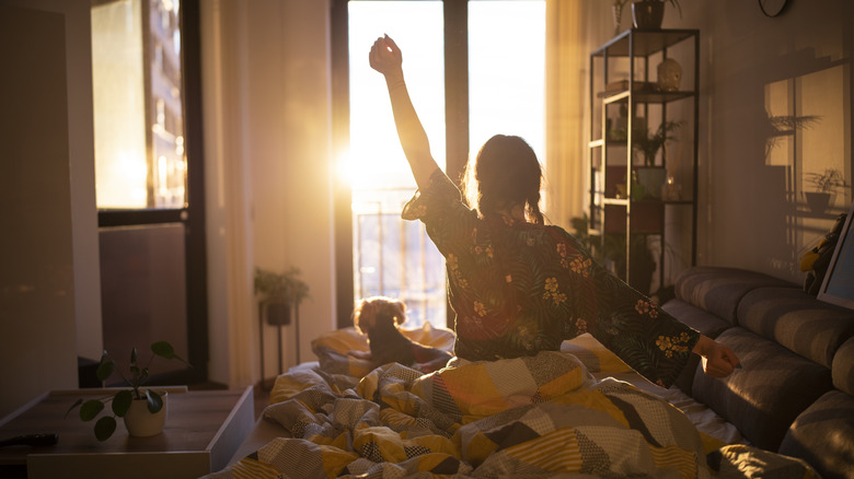 woman sitting up in bed stretching