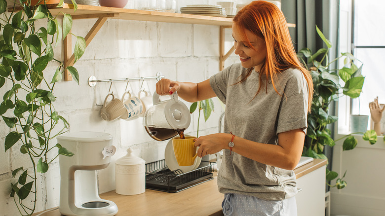 woman pouring mug of coffee