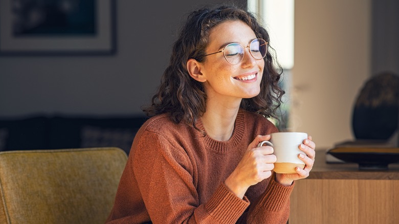 happy woman drinking mug of coffee