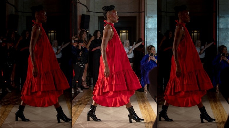 woman walking runway wearing bright red dress