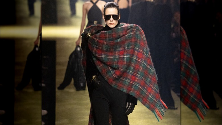 A model wearing a plaid blanket scarf