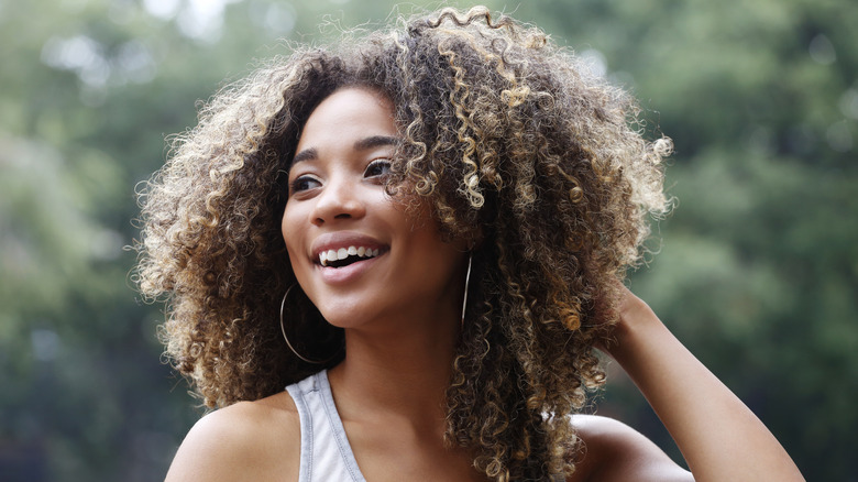 A woman with curly hair smiling.