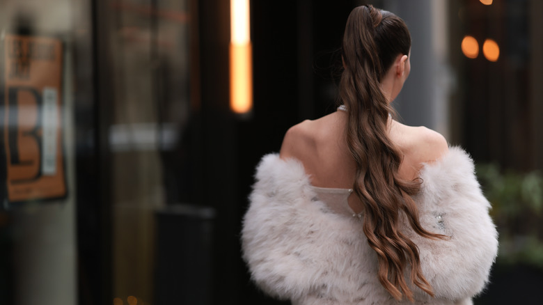 A woman wearing her hair in a voluminous long ponytail.