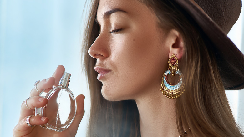 young woman smelling perfume 