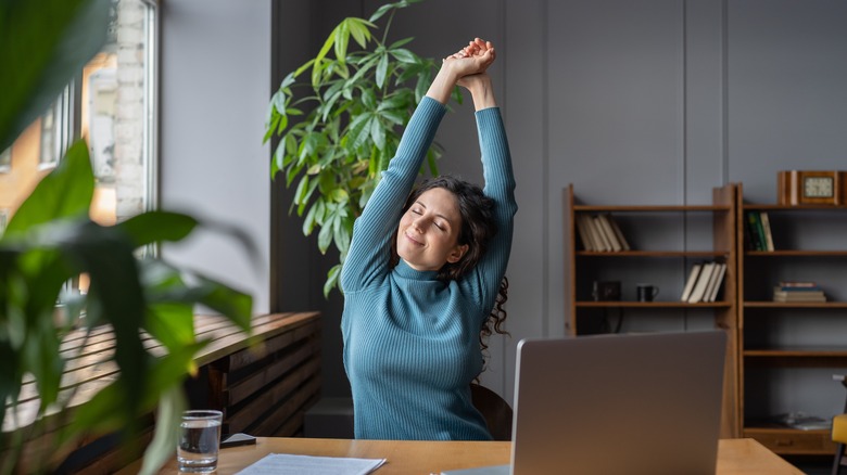 Woman stretching in office