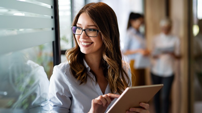 Woman smiling, working on tablet