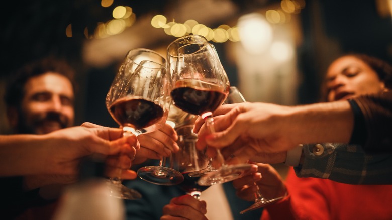 friends toasting red wine at night