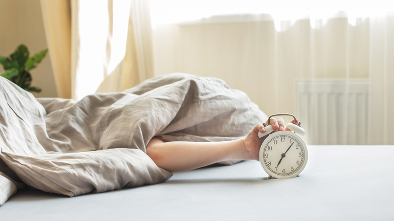 hand turning off alarm clock