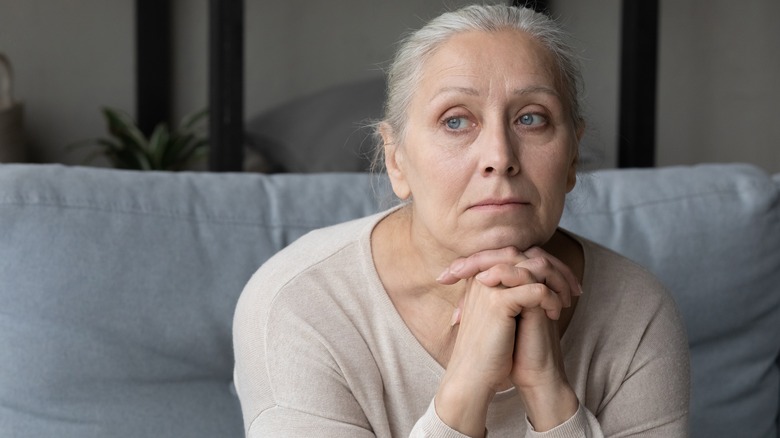 Woman sitting down, appearing lonely