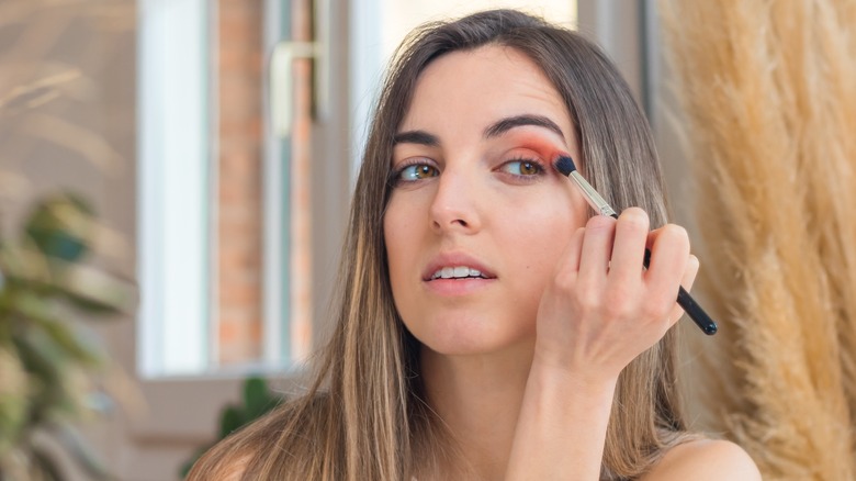 A woman putting eyeshadow on her eyes