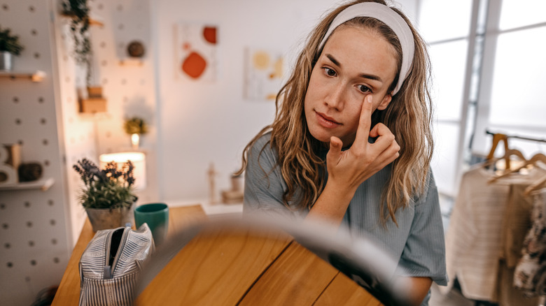 A woman applying eye cream