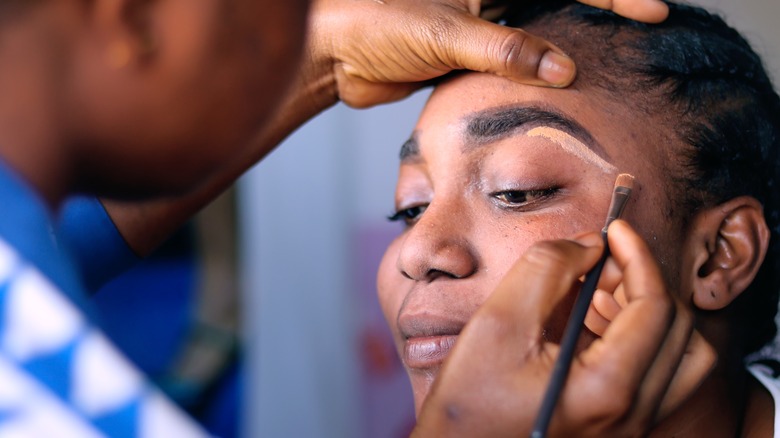 A woman getting her makeup done