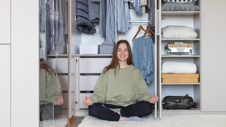 woman meditating in closet 