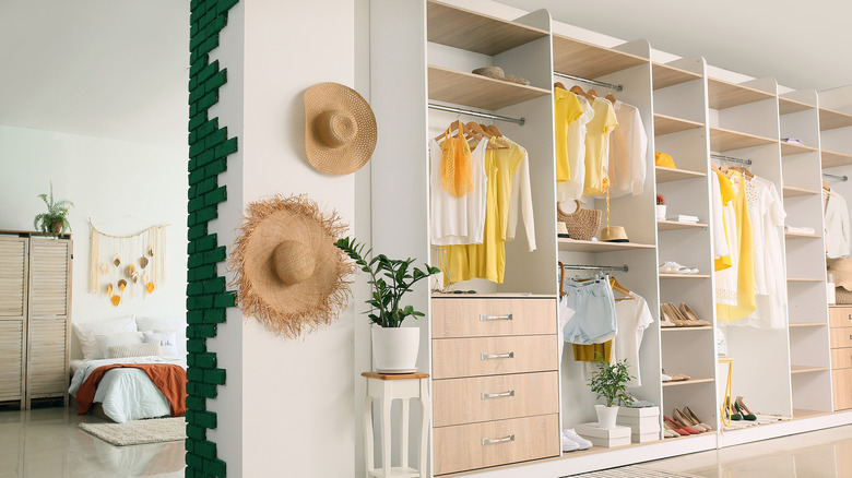 closet with straw hats hanging on the wall