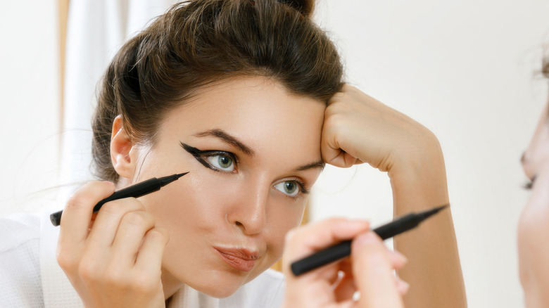 woman using eyeliner 