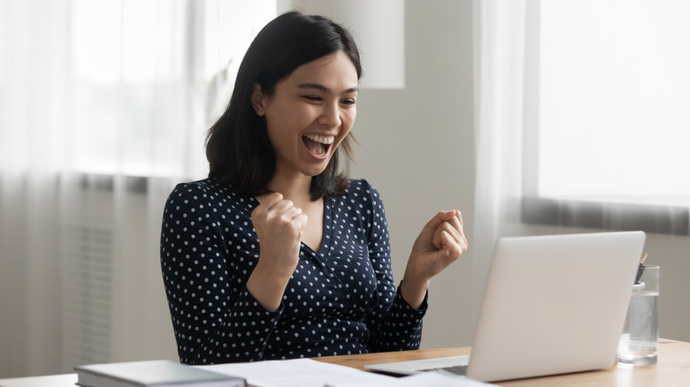 woman looking at laptop screen smiling