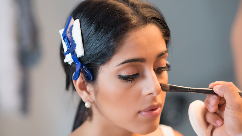 A woman getting her makeup done