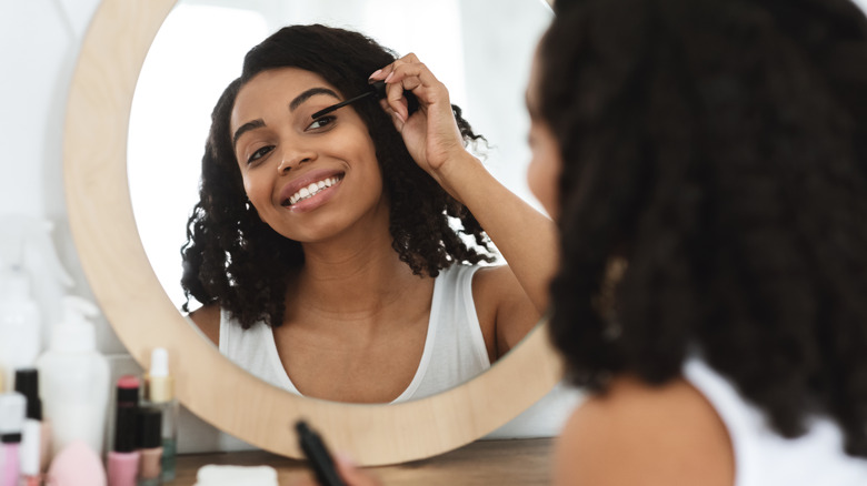 A woman applying mascara