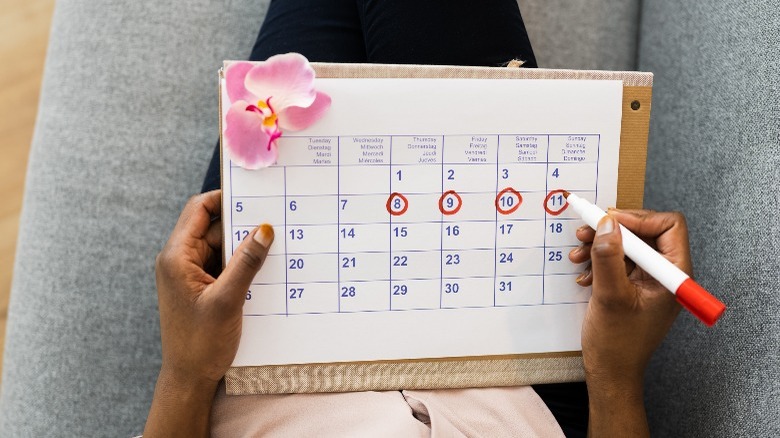 Woman marking period on calendar