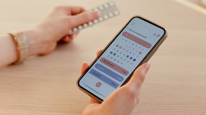 Woman holding birth control and calendar