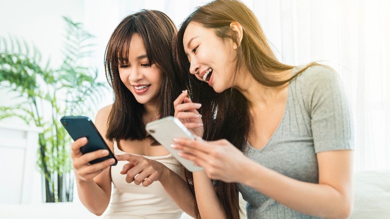 Woman laughing and looking at phones