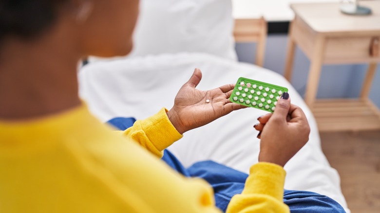 Woman holding birth control pills